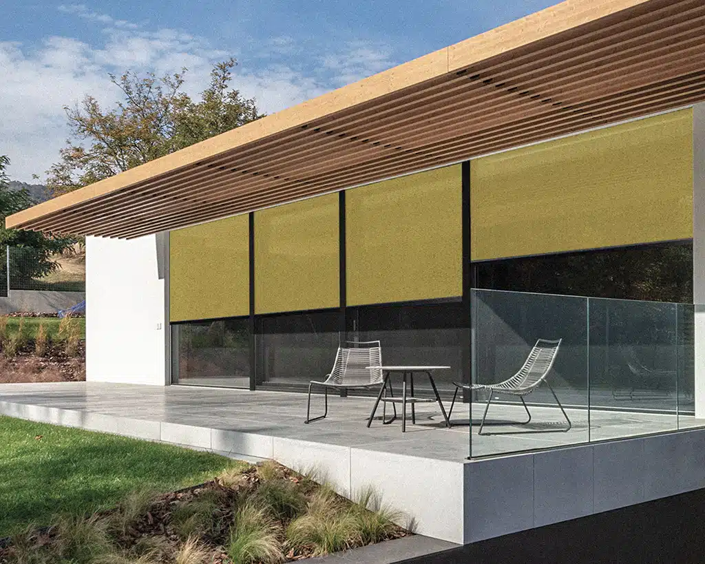 Modernes Wohnhaus mit großer Terrasse und gelben Textilscreens von KATZBECK als innovativer Sicht- und Sonnenschutz für die Glasfront.