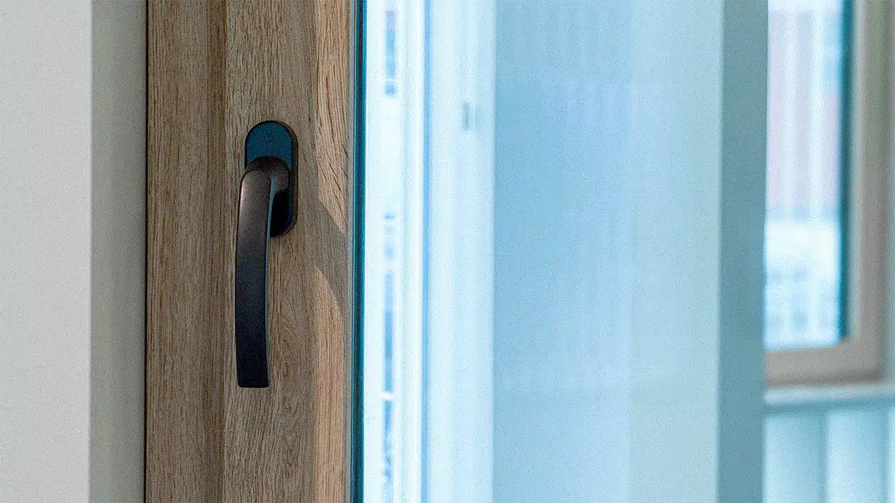 Kunststofffenster in Holzoptik mit schwarzem Fenstergriff